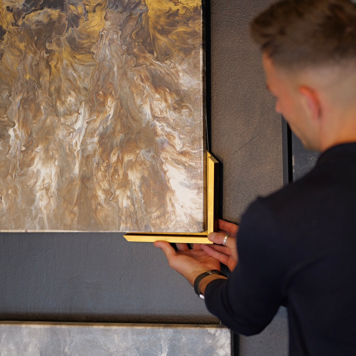 Artist holding framing to original artwork