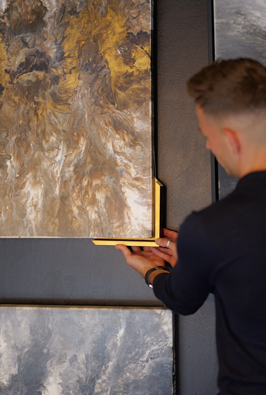 Artist holding framing to original artwork